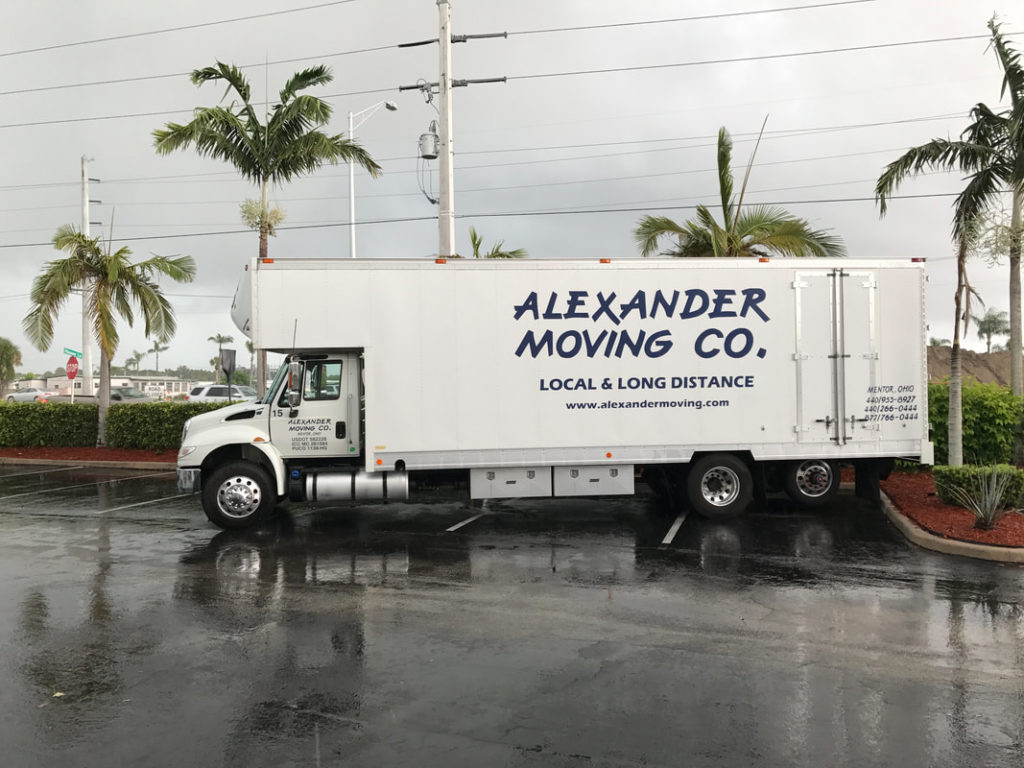 Alexander Moving Co. truck parked on wet lot.